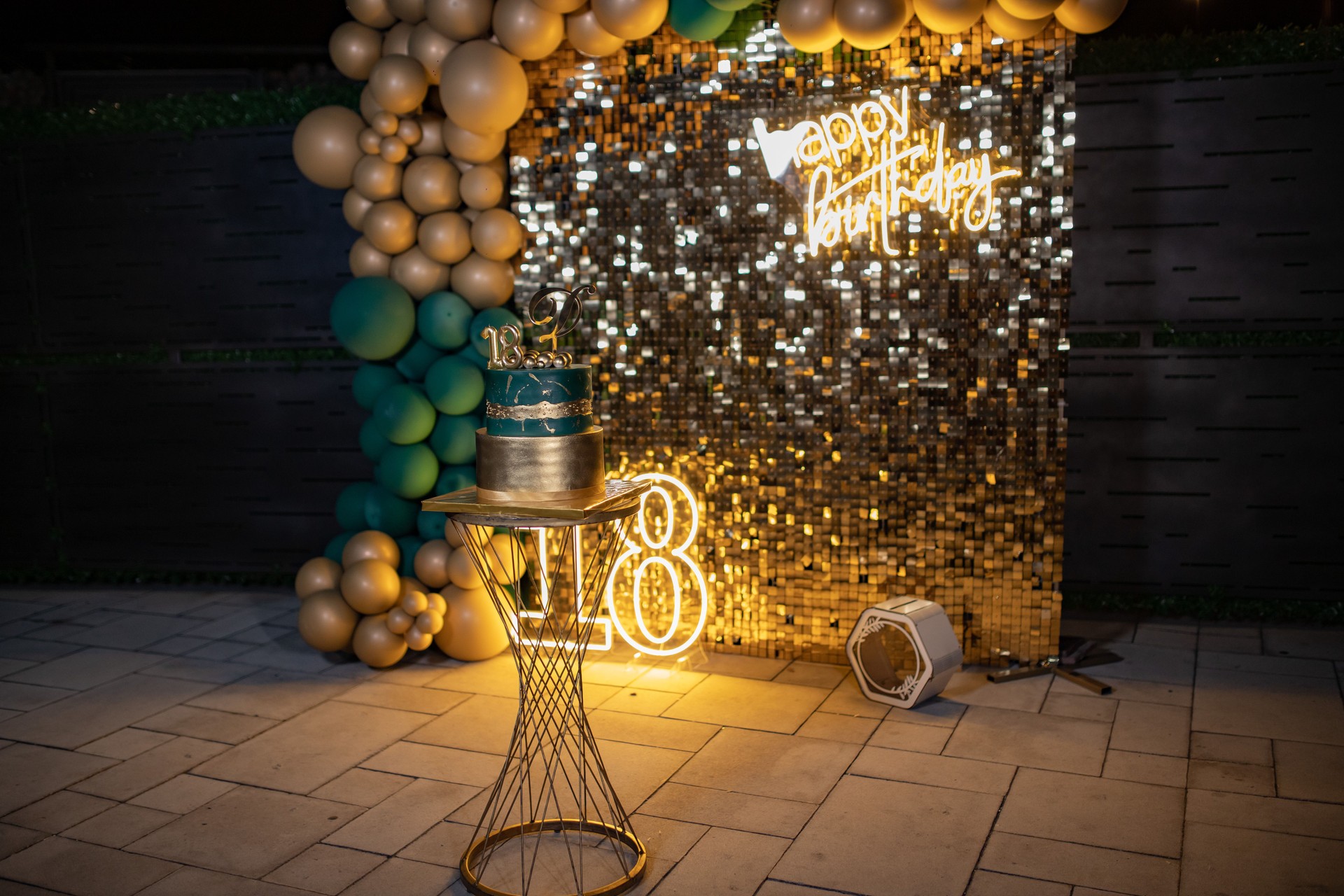 18 th birthday party decoration with balloons, cake and lighting text  "Happy birthday "